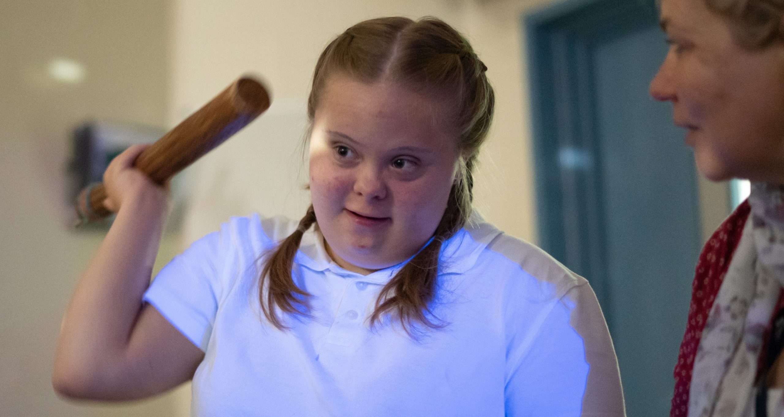 A girl is pictured smiling, whilst listening to the instructions of her teacher.