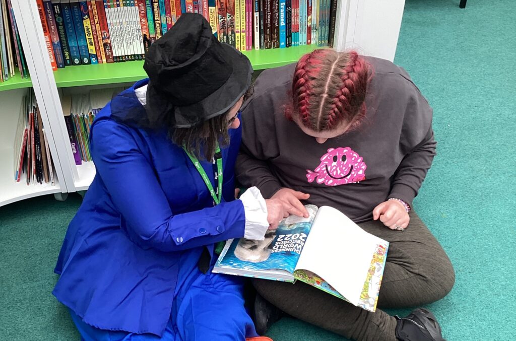 A student is seen reading a book together with a member of staff on World Book Day 2023.