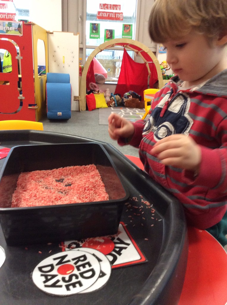 A young boy is seen engaged in an activity in his classroom on Red Nose Day 2023.