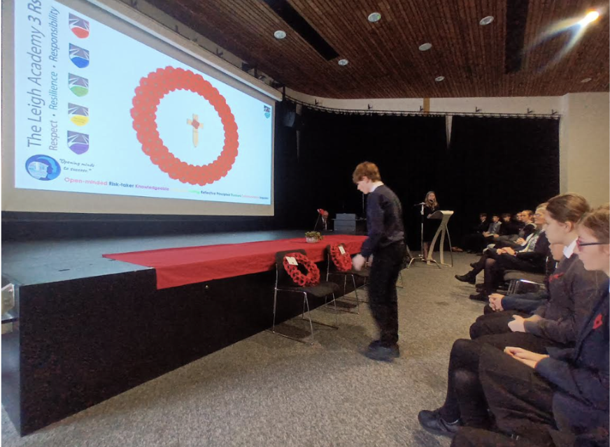 Student placing a poppy wreath on a chair