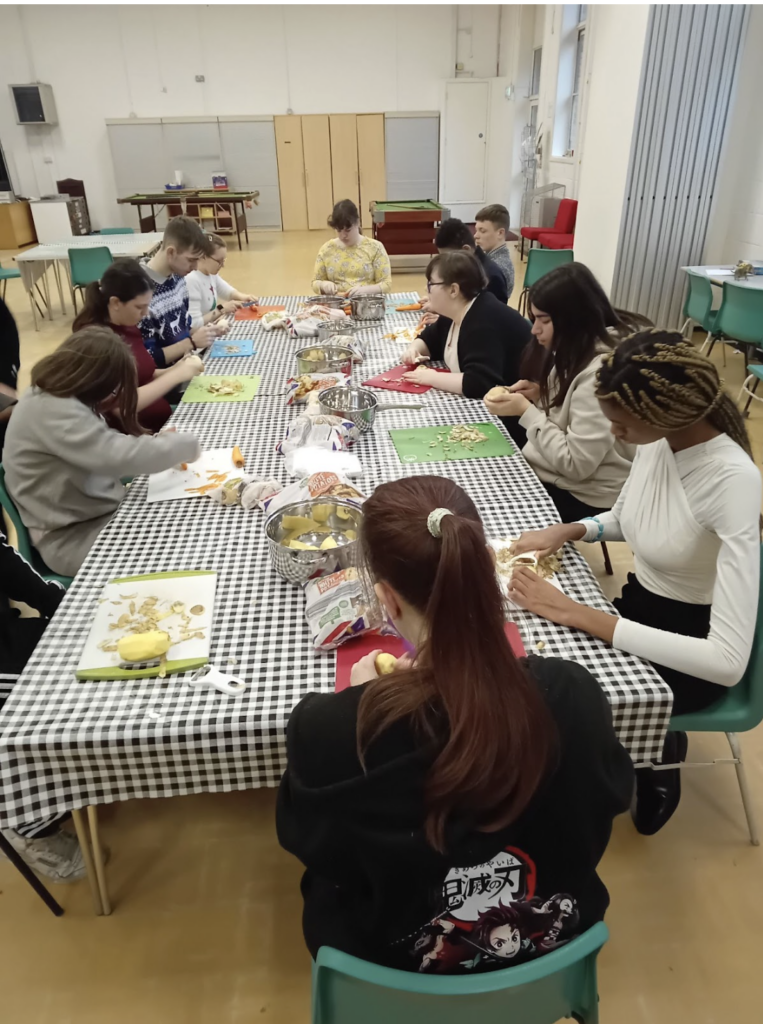 Students sat at a table preparing food for their Christmas dinner