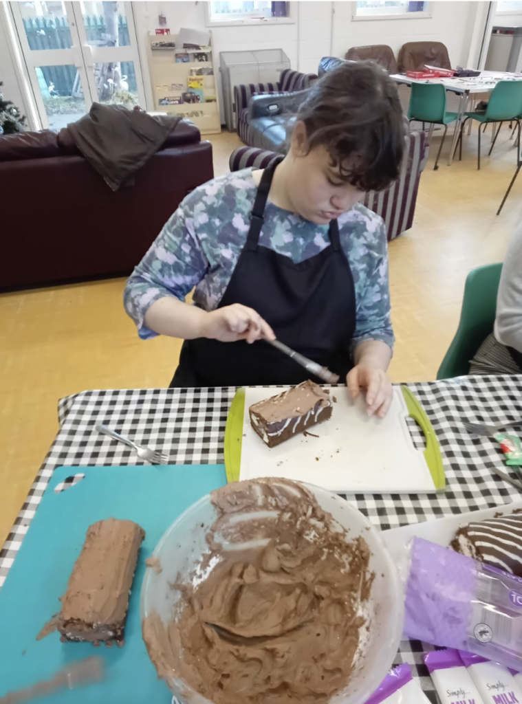 Student sat at a table preparing food for their Christmas dinner dessert