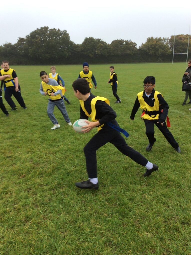 Students partaking in LAT tag rugby tournament in a grass field