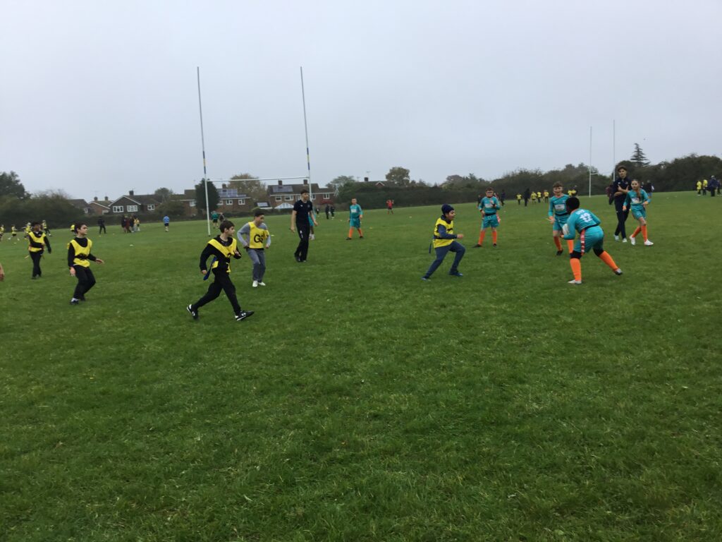 Students partaking in LAT tag rugby tournament in a grass field