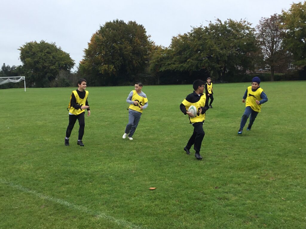 Students partaking in LAT tag rugby tournament in a grass field