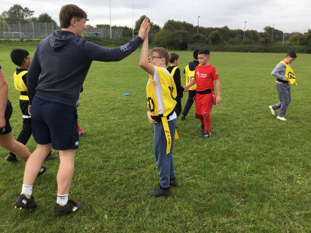 Students partaking in LAT tag rugby tournament in a grass field