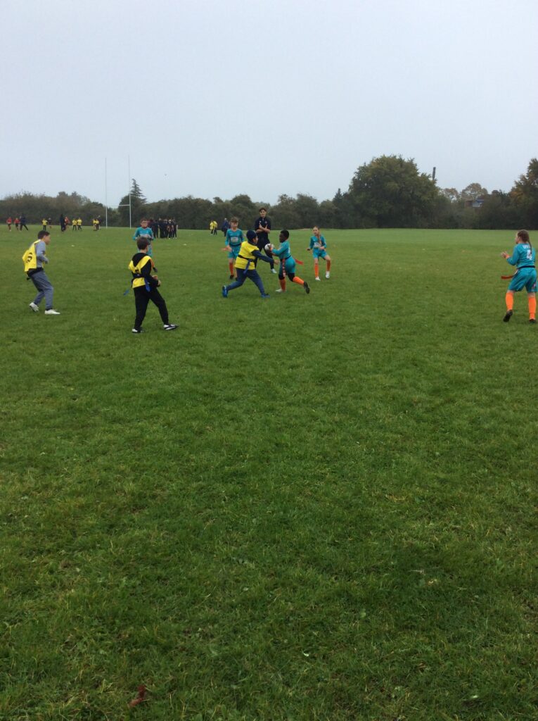 Students partaking in LAT tag rugby tournament in a grass field