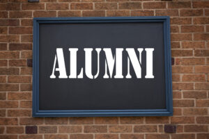 Conceptual hand writing text caption inspiration showing announcement Alumni Former Students. Business concept for Celebration Education Ending written on frame old brick background with space